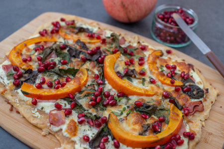 tarte flambee with pumpkin, cheese, kale and pomegranateの写真素材