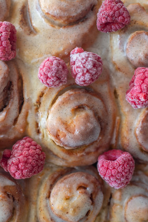 Delicious freshly baked cinnamon roll with raspberriesの写真素材