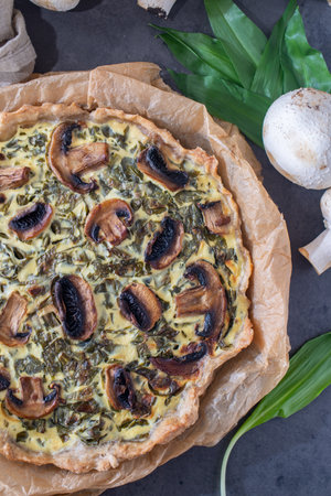home made quiche with wild garlic on a tableの写真素材