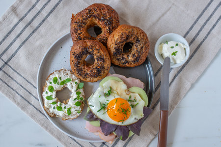 home made whole grain bagels with cheese on a tableの写真素材