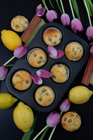 sweet home make lemon rhubarb muffins with tulips on a tableの写真素材