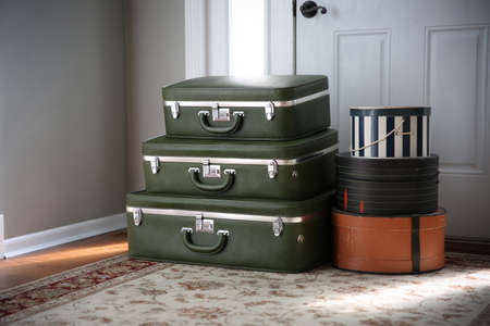 Set of vintage luggage and hatboxes waiting by the front door.