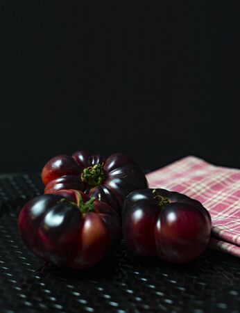 Tomatoes on black plate and napkin, delicious for summer in saladの写真素材