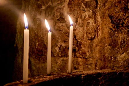 Three Candles in Line background stone wall