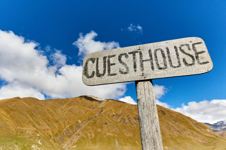 a sign of a guest house in the background of the mountains in Georgiaの写真素材