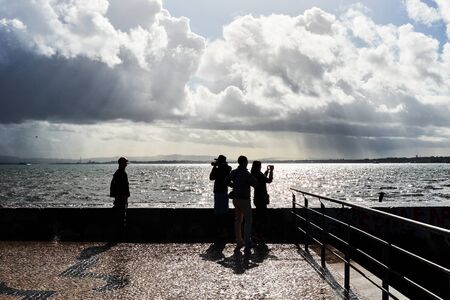silhouettes of people on the background of the ocean on a sunny day