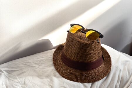 sunglasses lie on a straw hat dawnの写真素材