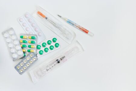 medicines in a package and a syringe lie on a white backgroundの写真素材