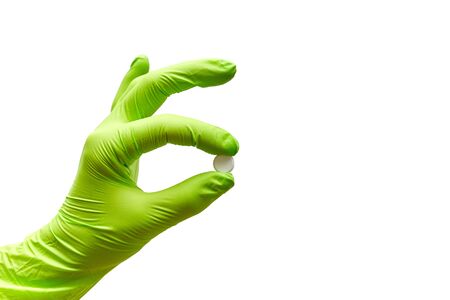 hand holds one tablet in fingers on a white backgroundの写真素材