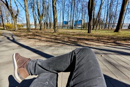 Legs of a guy in shoes top view on a background of nature on a sunny dayの写真素材