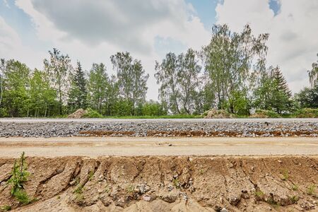 Construction of a road with rubble and sand on a sunny dayの写真素材