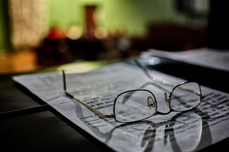 Glasses lie on paper with printed text Blurred backgroundの写真素材
