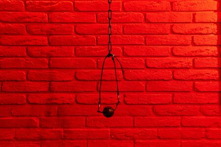 Black ball gag in mouth on red brick wall backgroundの写真素材