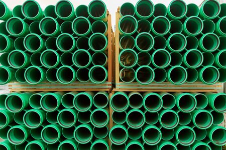 Green plastic pipes lie in rows cloudy dayの写真素材