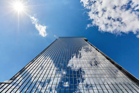 skyscraper against the blue sky in clear weather and the sun