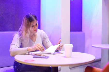 Student girl writing notes and drinking coffee
