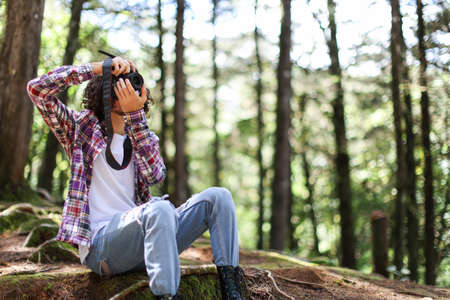 Faceless photographer taking picture looking right in the forest holding camera at Costa Ricaの写真素材