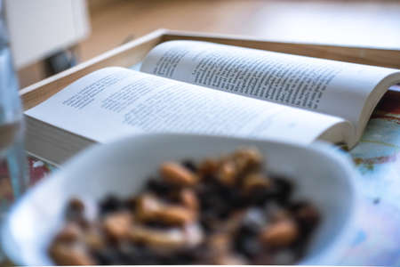 plate of nuts and a book, at homeのeditorial素材