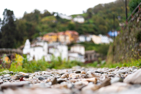 River stones texture with old town village background in the middle of the mountains next to the...
