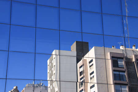 beautiful building with glass skin reflecting part of the cityの写真素材