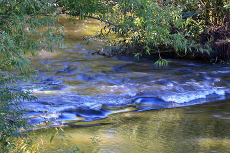 waterfall flowing under the bridgeの写真素材