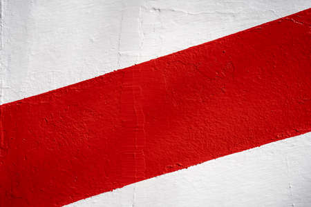Diagonal red stripe on a white wall. Background texture.の写真素材