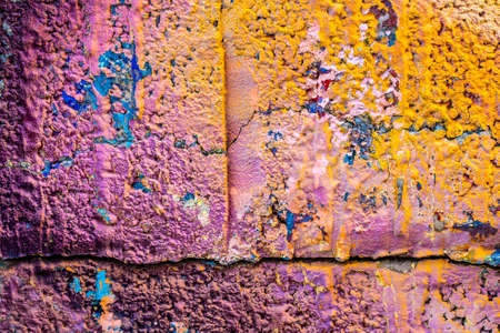 Multicolored purple orange graffiti close-up on rough concrete block wall texture. Street art background.の写真素材