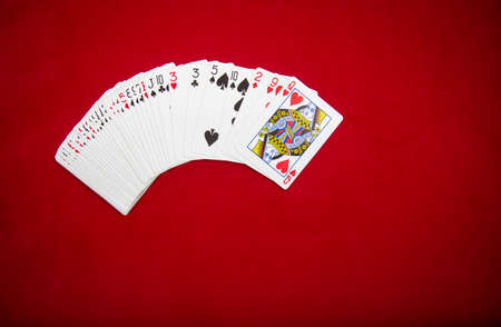 Deck of playing cards on red color velvet background. Top view with copy space.の写真素材