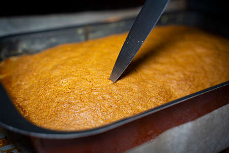 Pricking a sponge cake with a knifeの写真素材