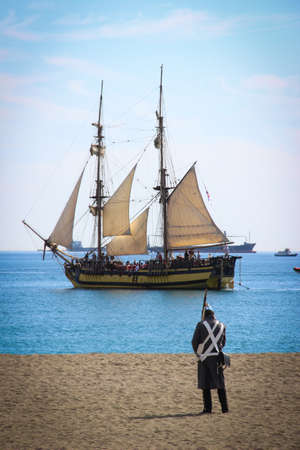 Malaga, Spain - October 26, 2014: Brig La Grace next to the coast. Napoleonic soldier on a beach. Historical reenactment of the British landing of 1812. Royal Navy assault on a corsair base.のeditorial素材