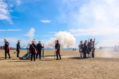 Malaga, Spain - October 26, 2014: 18th century french soldiers firing a cannon with gunpowder. Men and women reenactors. Historical reenactment of a Napoleonic corsair base.のeditorial素材
