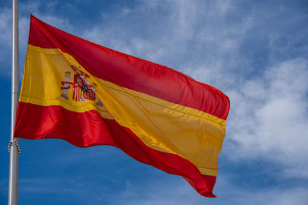 Spanish flag waving against the blue skyの写真素材
