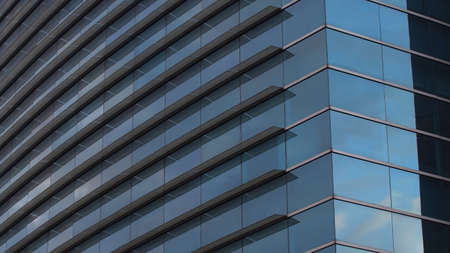 Modern building with glass windows reflected sky