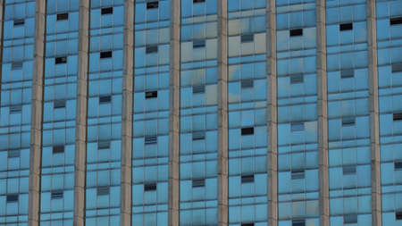 Modern building with glass windows reflected skyの写真素材