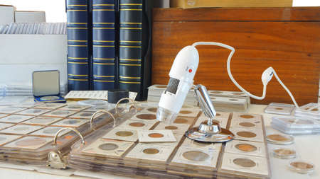 Digital microscope on album with coins from different countries - Numismatic sceneの写真素材