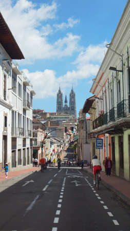 Quito, Pichincha / Ecuador - January 22 2016: People walking on a bicycle in the Historic Center of Quito with the Basilica of the National Vow in backgroundのeditorial素材