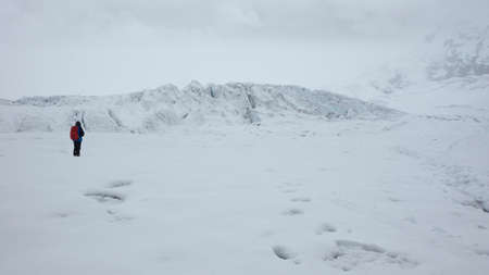 Lonely man on the glacier of the volcano Antisana on a cloudy day in the Antisana Ecological Reserve - Ecuadorの写真素材