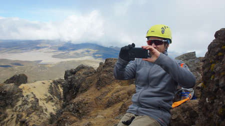 Cotopaxi National Park, Cotopaxi / Ecuador - August 2 2017: Male climber taking photos of the landscape from the top of the Ruminahui volcano inside the Cotopaxi National Parkのeditorial素材
