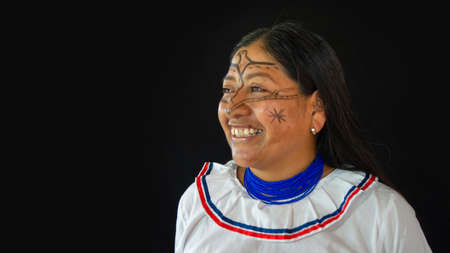 Lago Agrio, Sucumbios / Ecuador - February 29 2020: Woman from the Quichua ethnic group of the Ecuadorian Amazon smiling in profile with her traditional dress on a black backgroundのeditorial素材
