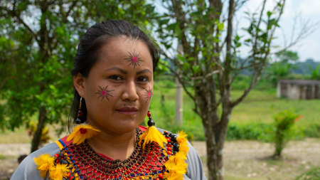 Lago Agrio, Sucumbios / Ecuador - February 20 2020: Cofan ethnic woman wearing traditional clothing adorned with necklace and earrings made with seeds and feathers in the Cofan Dureno communityのeditorial素材