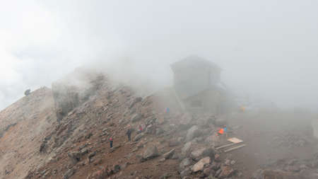 Cayambe, Pichincha / Ecuador - February 24 2020: Group of tourists looking at the landscape of the Cayambe volcano near the Ruales Oleas Berge refuge on a cloudy dayのeditorial素材