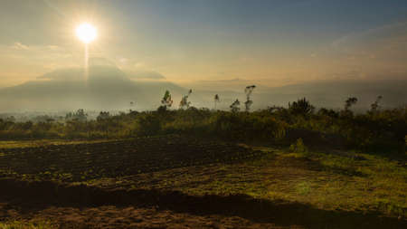 Landscape of Ecuador, view of Imbabura volcano in a cloudy sunrise with the sun rising behind the...