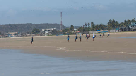 Palmar, Santa Elena / Ecuador - October 19 2019: Group of artisanal fishermen pulling a rope to pull...