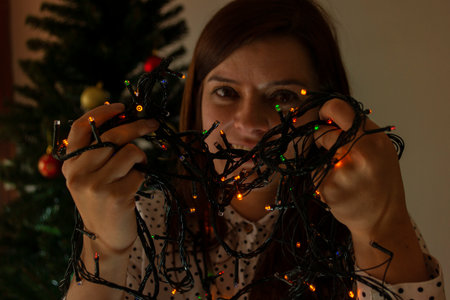 Close-up to the face of a smiling woman playing with lights of red, green and blue colors to...