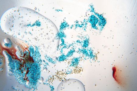 Abstract composition with water, oil drops and blue ink against white backgroundの写真素材