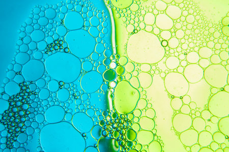 Abstract composition with water and oil drops against a two-tone blue and green backgroundの写真素材