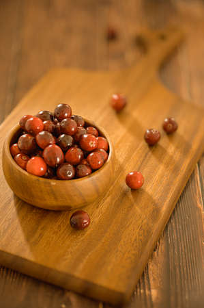 Cranberry recipe in home kitchen. Cranberry mocktail ingredients for make natural beverage and drink. Fresh red berries in wooden bowl.の写真素材