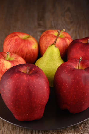 Photo shows several apples and one pear. Photo was taken in studio using special light. Red apple glistens like glossy - this is natural effect.の写真素材