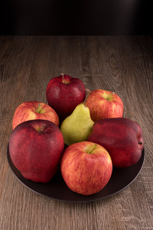 Photo shows several apples and one pear. Photo was taken in studio using special light. Red apple glistens like glossy - this is natural effect.の写真素材