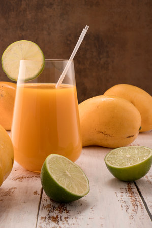Photo shows glass transparent with natural fresh mandarine drink on vintage textured. In background,...